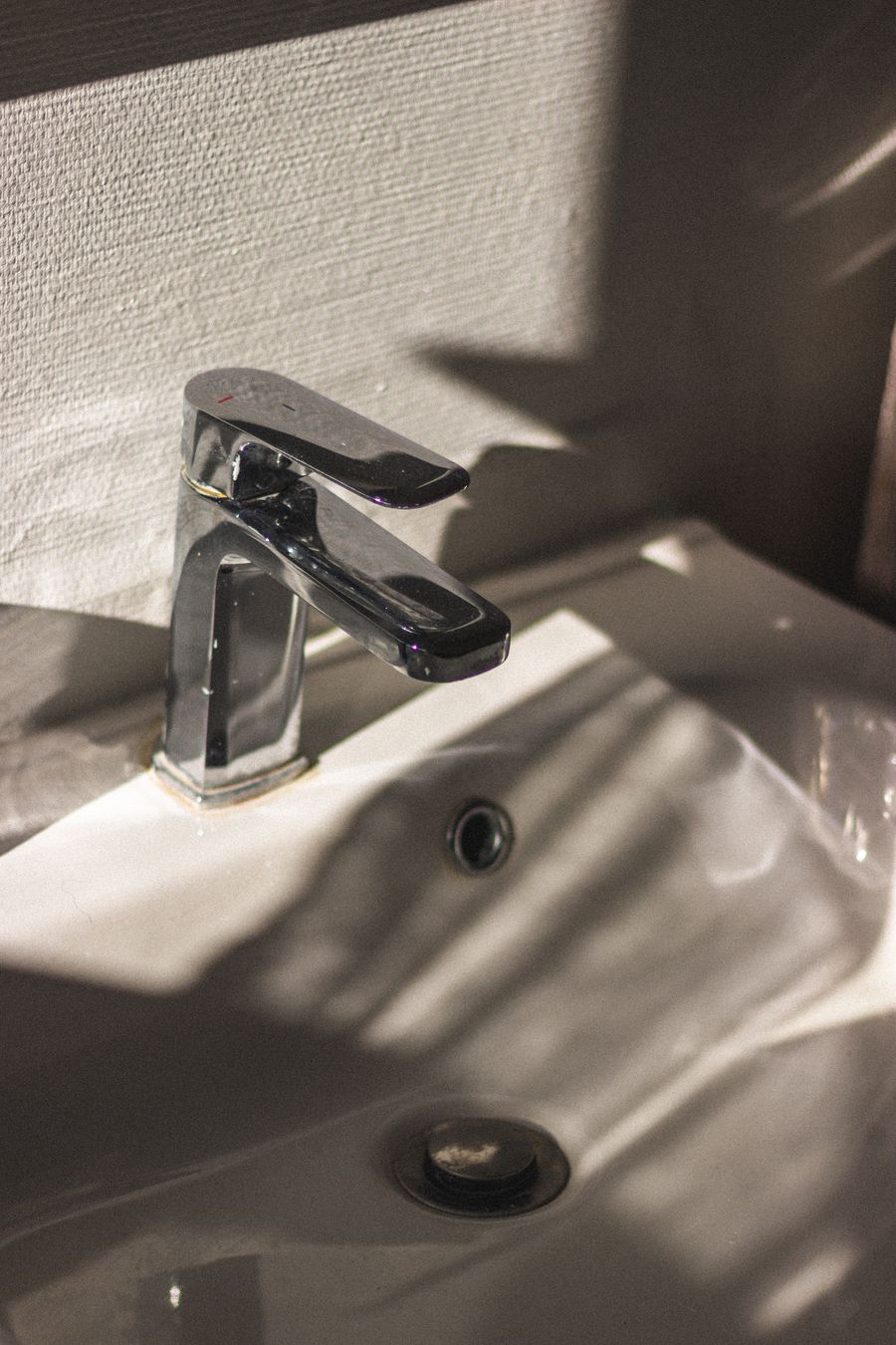 Chrome single-lever basin mixer on a white ceramic basin